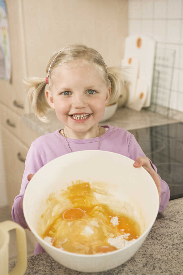 Girl Holding Bowl Of Egg Yolk And Flour Smiling Portrait Rnf Robert Niedring Westend61