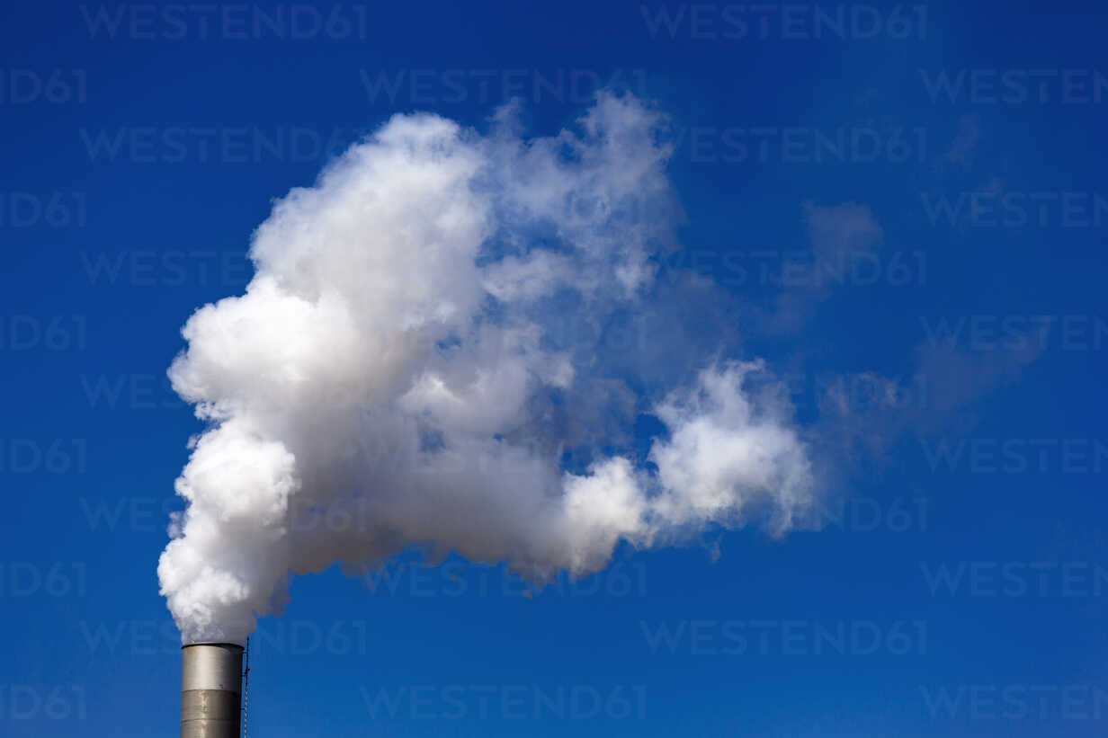 Germany Chimney With White Smoke Against Blue Sky Stockphoto