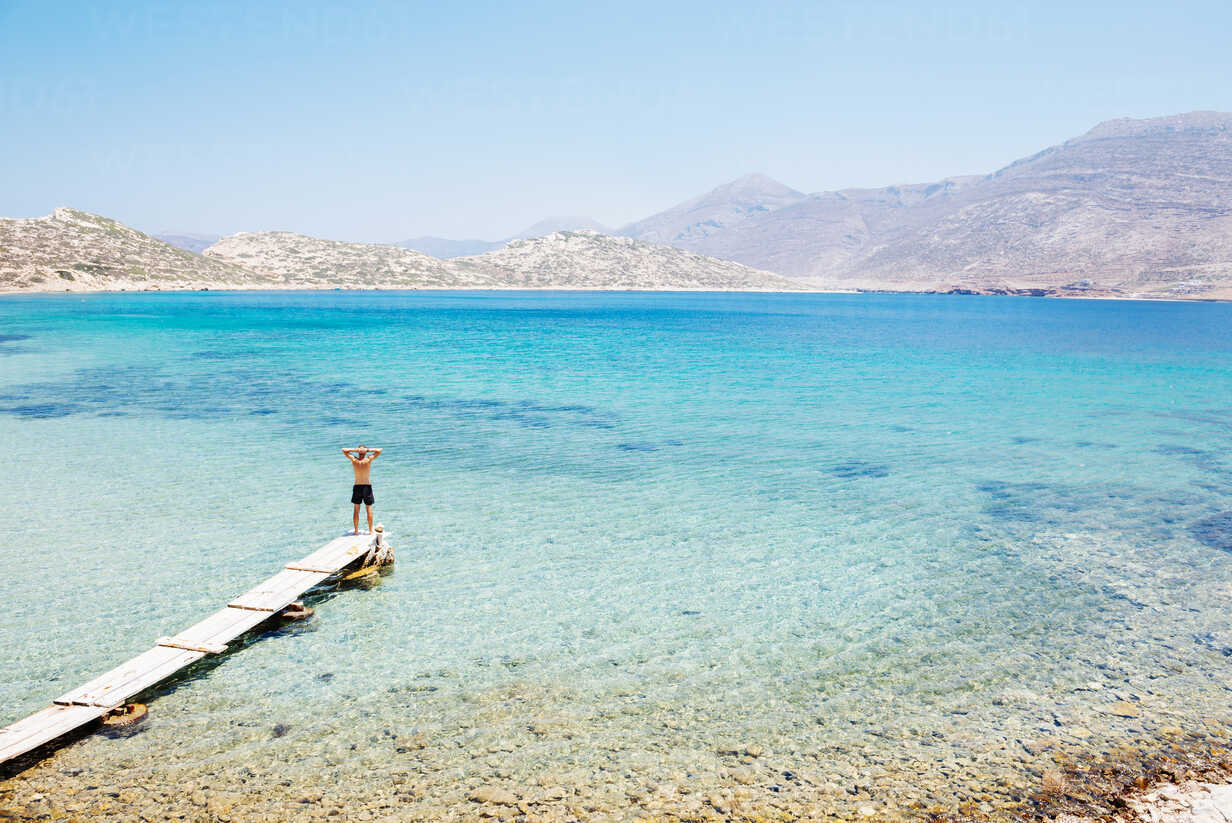 Greece Cyclades Islands Amorgos Aegean Sea Man Standing On The Edge Of A Wooden Dock Gemf