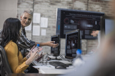 Adult Education Instructor Talking To Student At Computer Training Centre Stockphoto