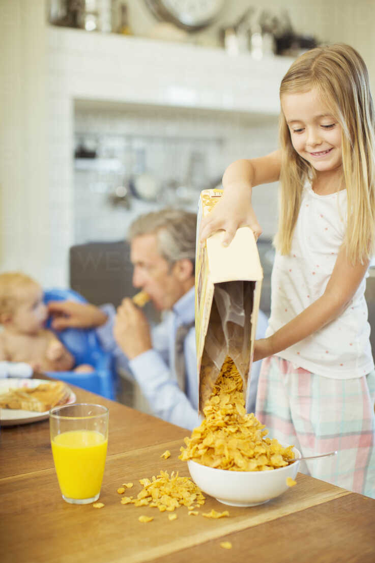 Girl Pouring Bowl Cereal On Breakfast Table Stockphoto