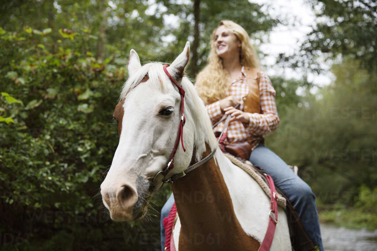 Smiling Woman Looking Away While Riding On Horse CAVF17218 Cavan