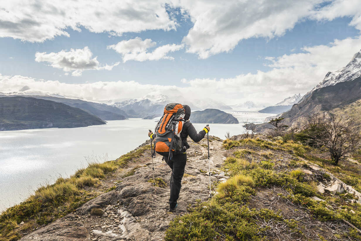 Rear view of female hiker hiking alongside Grey glacier 