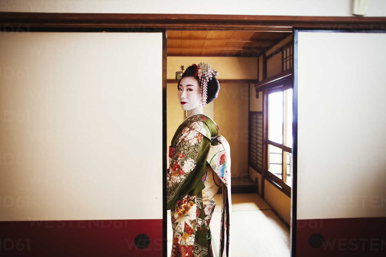 A Woman Dressed In The Traditional Geisha Style Wearing A Kimono And Obi With An Elaborate