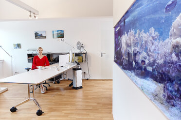 Young Woman Using Smartphone In Office With An Aquarium Rhf02158
