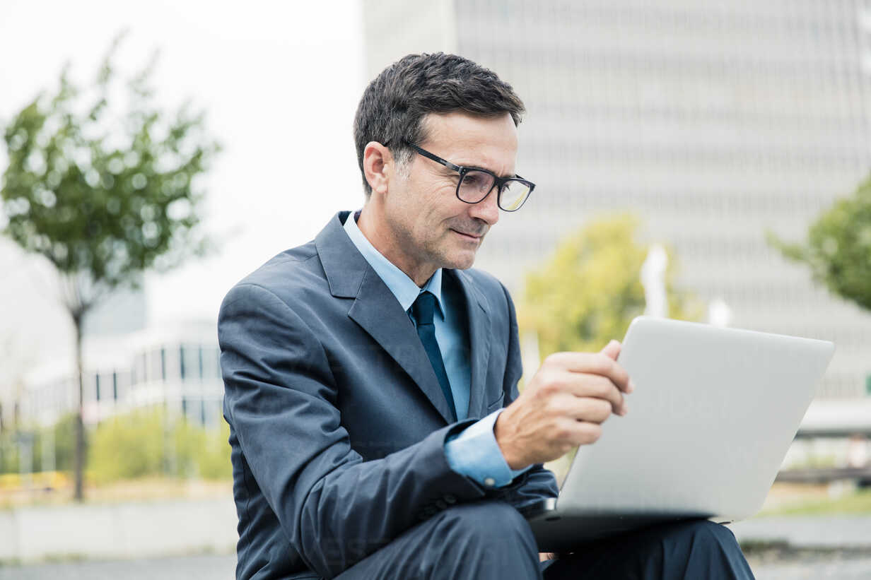 Businessman Sitting Down Using Laptop In The City Moef Robijn Page Westend61