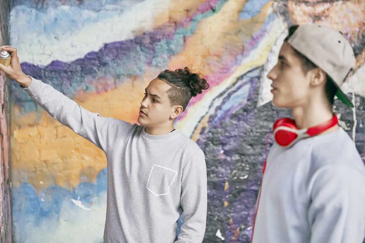 Teenage Boys Spray Painting On Wall Stockphoto