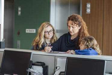 Young Nurse Explaining The Spine To Mature Patient In Hospital