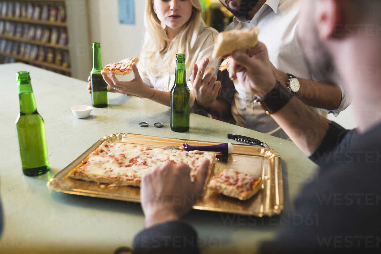 Kollegen Bei Pizza Und Bier Im Buro Stockfoto