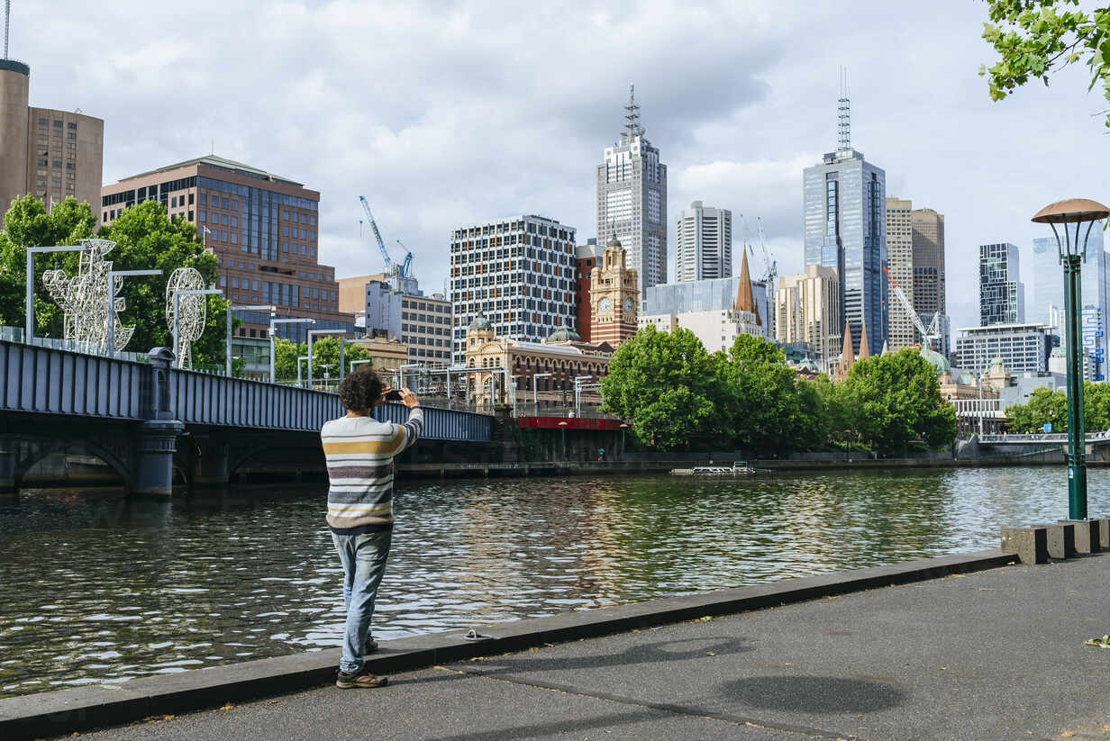 Man Taking A Picture Of Cityscape Of Melbourne With Yarra River Victoria Australia Stockphoto