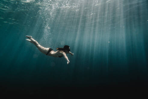 Full length of woman swimming underwater in the ocean - CAVF63540 ...
