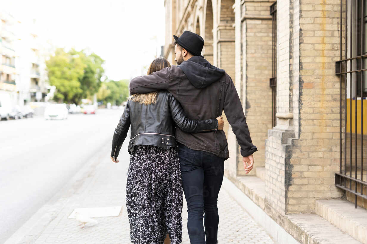 Back View Of Young Couple In Love Walking Arm In Arm In The City Errf Eloisa