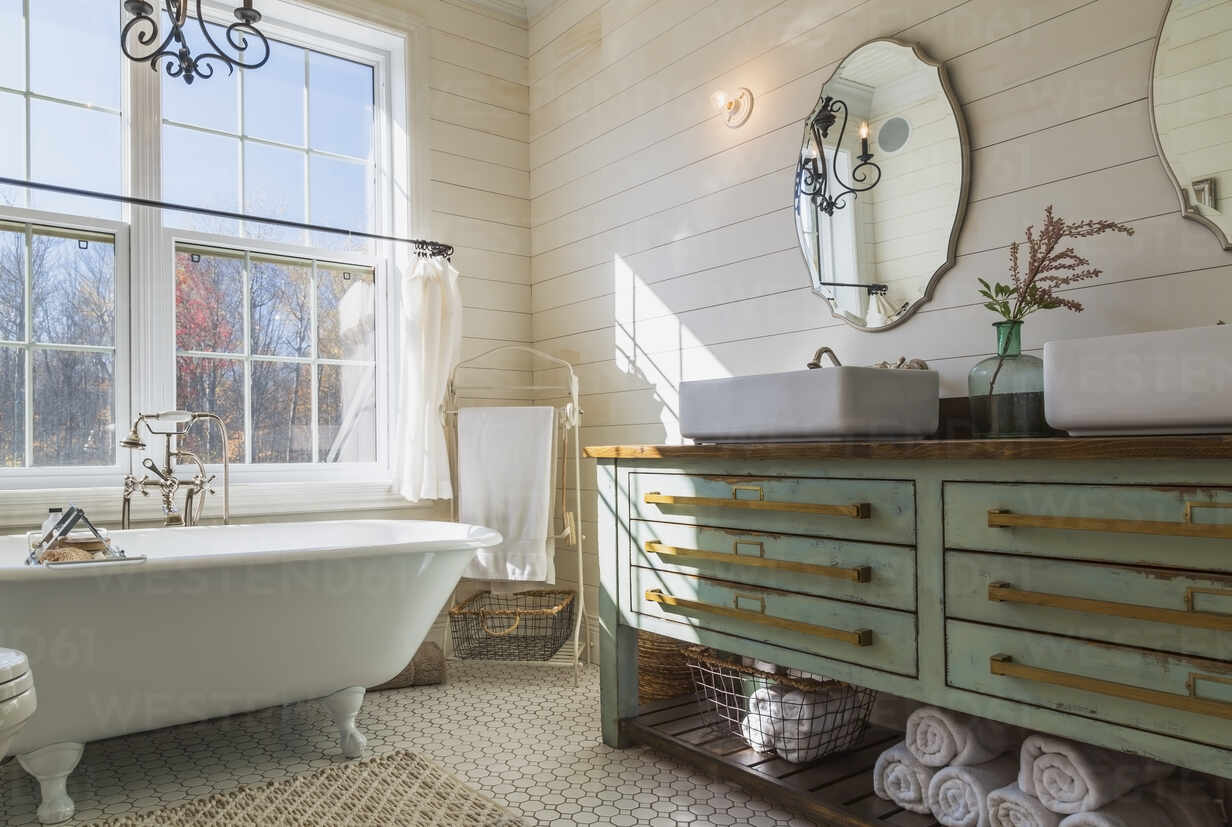 Bathroom With White Roll Top Bath Cream Tiled Floor And Wood Panelled Walls Green Vanity Unit