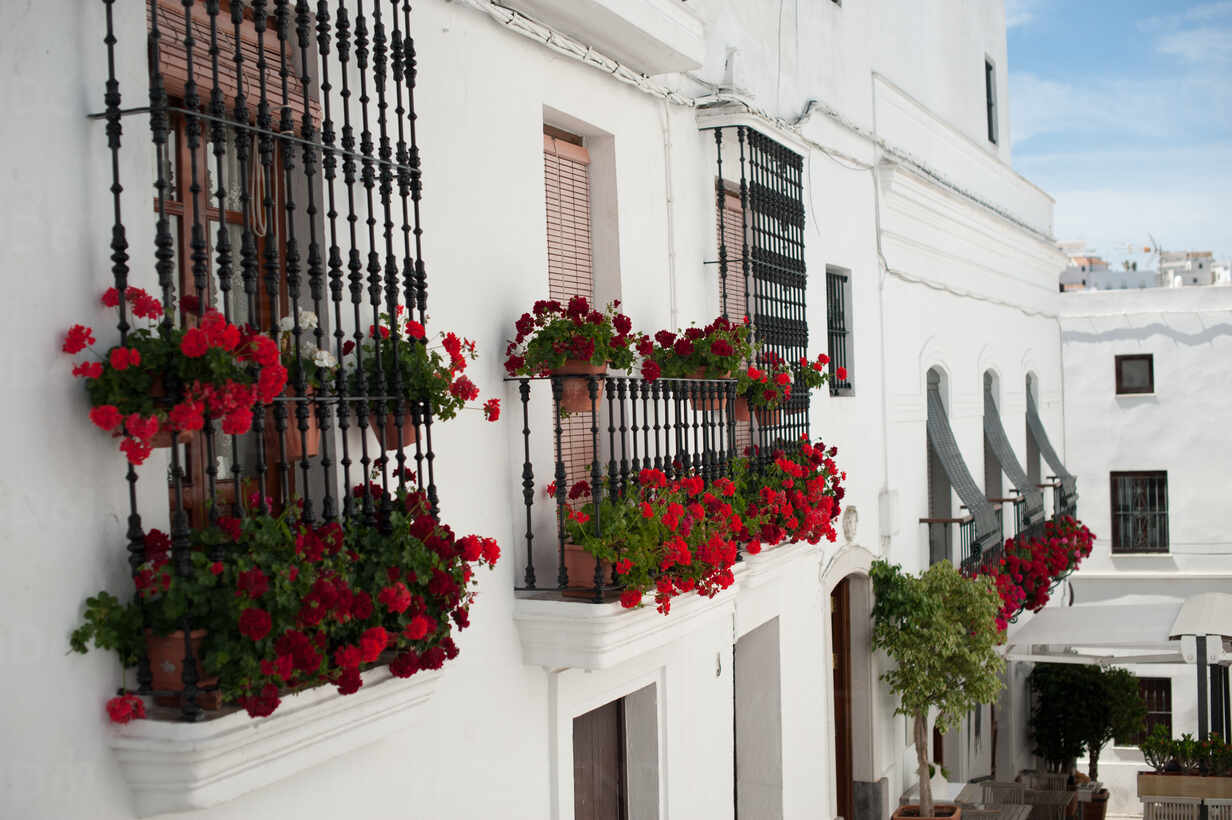 Red Flowers On Balconies In White Village In Spain Stockphoto