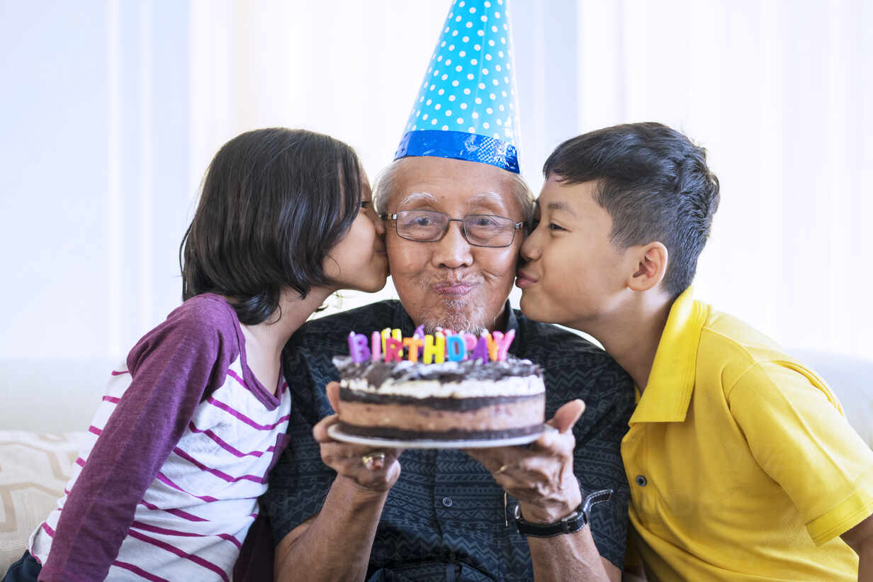 Download Grandparents And Grandchildren With Birthday Cake At Home Stockphoto