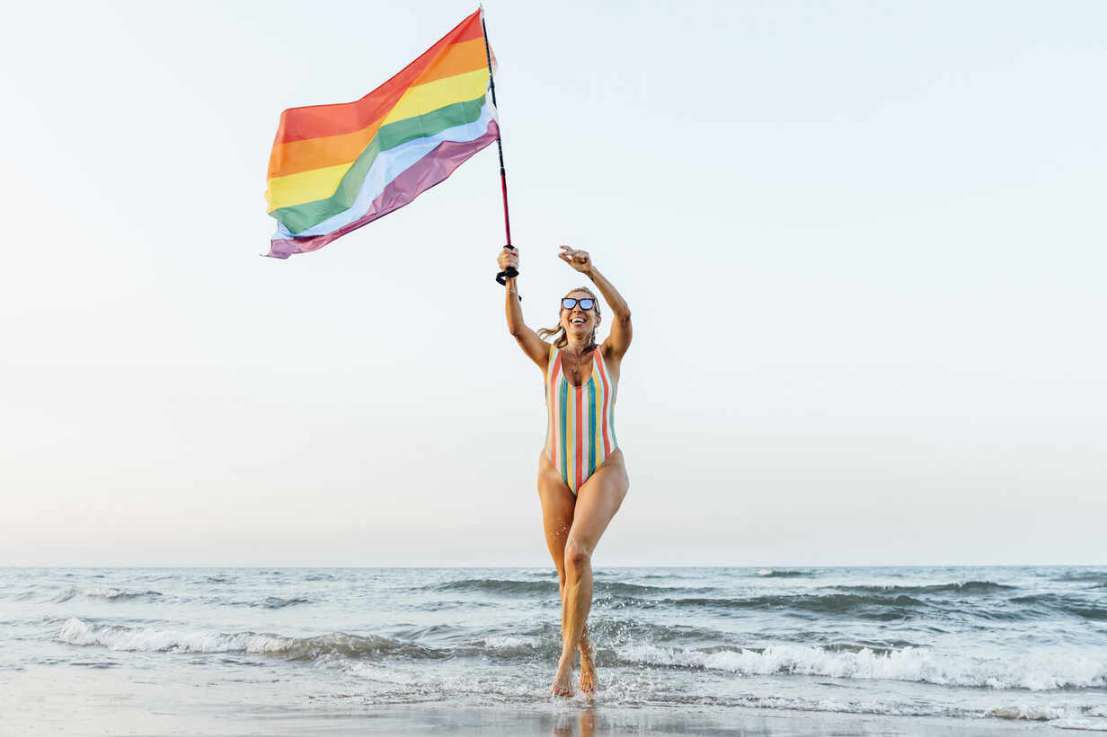 Mature Woman Running On The Beach With Gay Pride Flag Cjmf Jesus Martinez Westend61