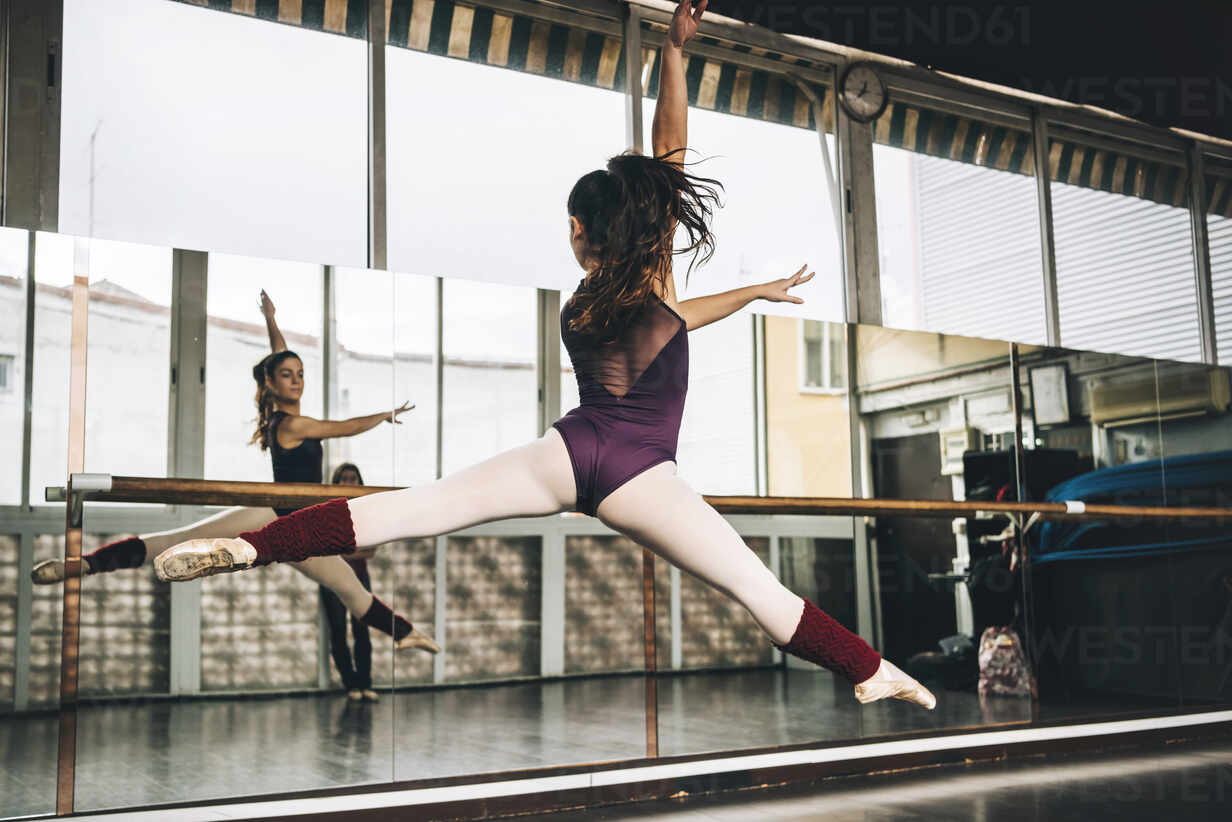 Back View Of Young Slim Ballerina Jumping Above Ground In Studio Flexing Legs Adsf Addictive Stock