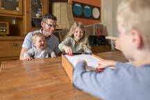 Smiling Family Watching Kids Playing Air Hockey On Dining Table At Home Moef03082 Robijn Page Westend61