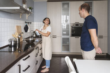 Husband And Wife Preparing Food In Kitchen At Home Stockphoto
